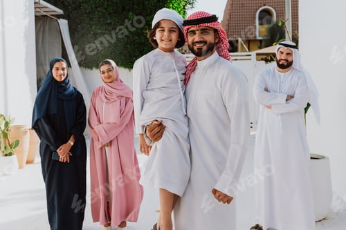 Preview: Emirati family standing together smiling in traditional attire