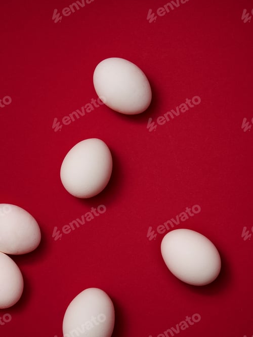 Preview: Elegant white eggs on a rich red background.