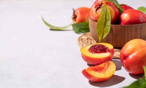 Preview: Juicy and sweet nectarines in a bowl on a light background with shadow. Healthy organic farm fruit