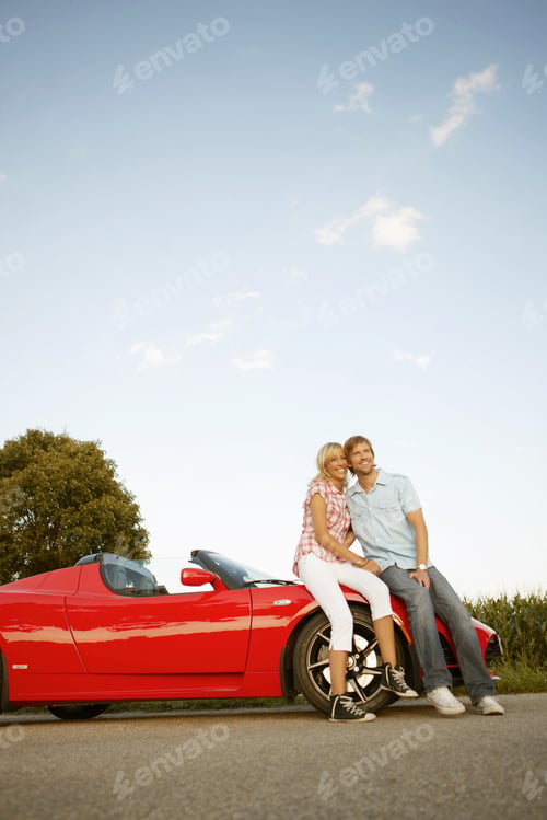 Preview: Couple sitting on electric sports car