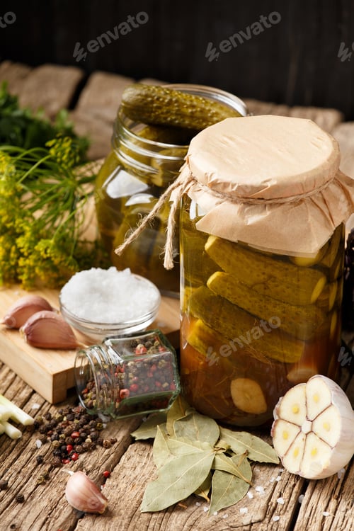 Preview: Canned cucumbers in jars, salt, spices and seasonings for marinade on a wooden background