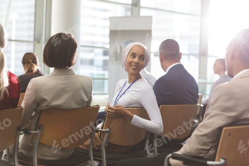 Preview: Businesswoman interacting with his colleague during seminar in office building