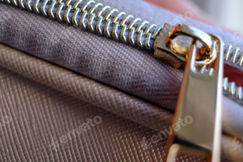 Preview: Selective focus, yellow metal zipper of a makeup bag or small purse macro pattern background