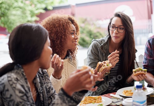 Preview: This is the best place in town. Cropped shot of a friends eating burgers outdoors.