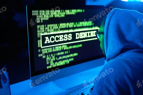 Preview: Theres a crack on every wall. Shot of a young male hacker cracking a computer code in the dark.