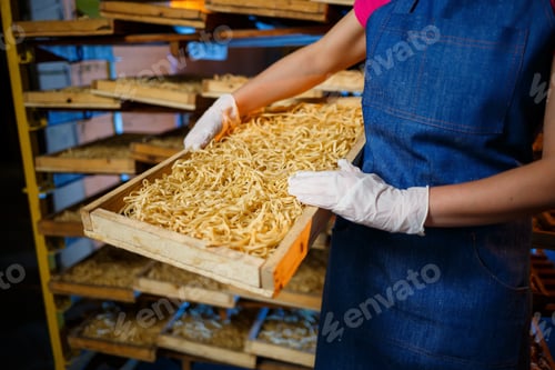 Preview: The girl works on the production of spaghetti. Making noodles. Pasta factory. Stage production
