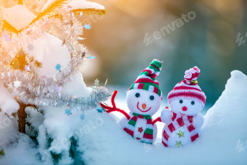Preview: Two small funny toys baby snowman in knitted hats and scarves in deep snow