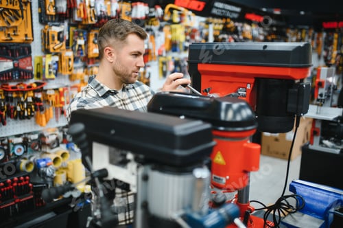 Preview: A man in a hardware store choosing a tool