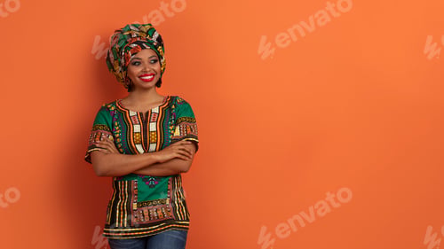 Preview: Cheerful african woman in traditional costume looking at copy space