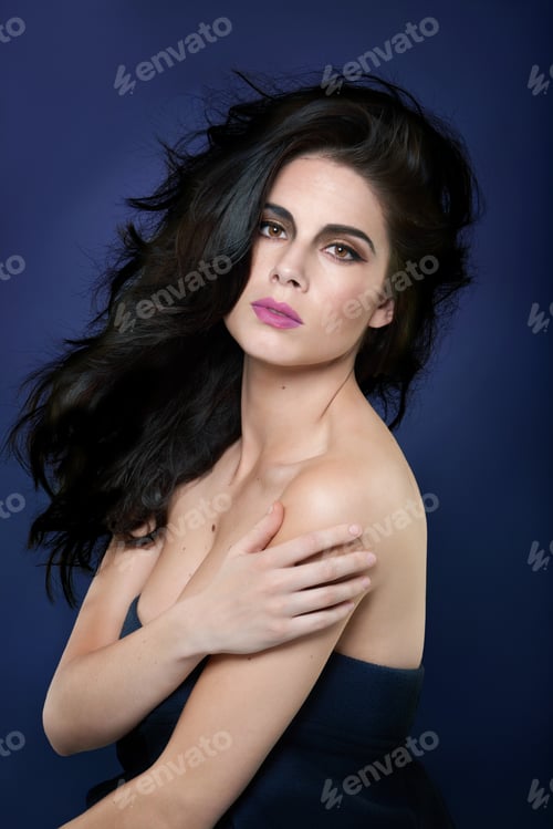 Preview: Portrait of a beautiful young woman posing against a blue background