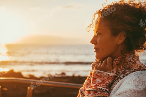 Preview: Enjoyed and serene lady dreaming and thinking outdoor with ocean beach and sunset light