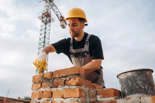 Preview: Bunch of bricks, busy. A builder is working at the construction site at daytime