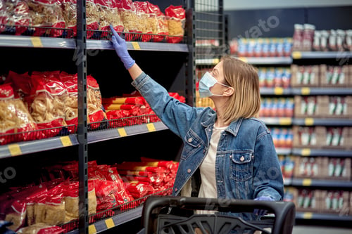 Preview: Beautiful Girl In The Store Chooses Pasta. Woman In A Medical Mask And Gloves