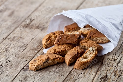 Preview: Traditional Italian cookies cantuccini on white paper bag on ructic wooden table background.
