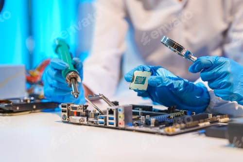 Preview: Close-up of a technician wearing gloves soldering electronic components at a desk in an office