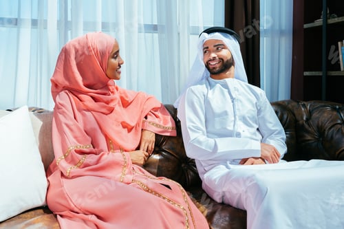 Preview: Happy middle eastern couple wearing traditional arab clothing at home