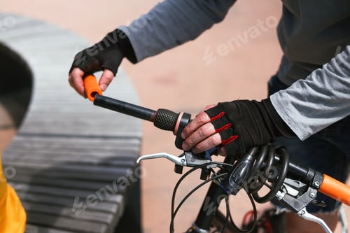 Preview: Hands of a bicycle mechanic installing new handlebar grips