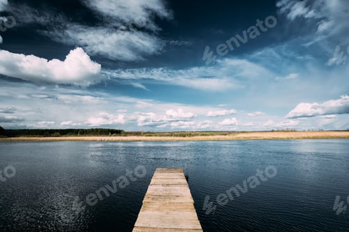 Preview: Old Wooden Boards Pier On Calm Water Of Lake Or River At Evening