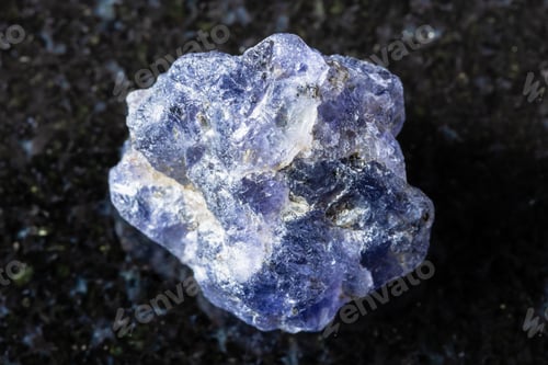 Preview: sample of rough iolite mineral on black granite