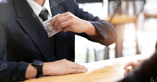 Preview: Businessman putting banknotes of dollars in suit pocket. Corruption concept with copy space