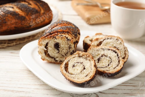 Preview: Plate with freshly baked poppy seed roll on table
