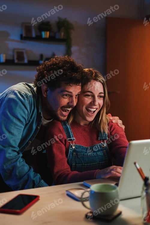 Preview: Vertical. Happy young caucasian couple smiling and having fun watching streaming videos on social