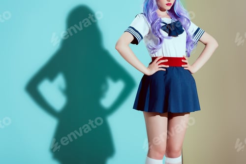 Preview: cropped shot of stylish girl in bright wig and skirt standing with hands on waist in studio