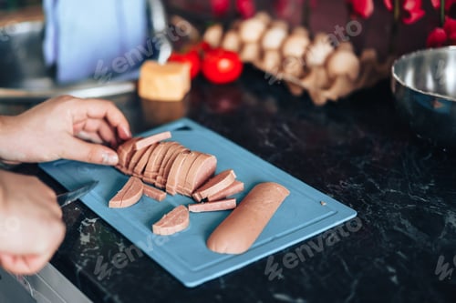 Preview: Man makes pizza at home in the kitchen. Cuts the pizza sausage into strips