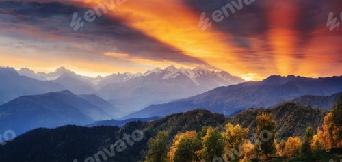 Preview: Sunset over snow-capped mountain peaks. The view from the mounta