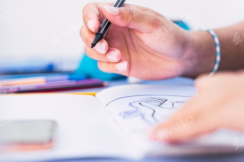 Preview: Caucasian woman writing and drawing in a notebook with a pen