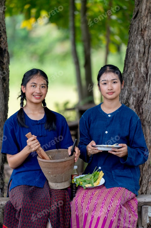 Preview: Portrait of two Asian girls hold plate and motar and look at camera with smiling