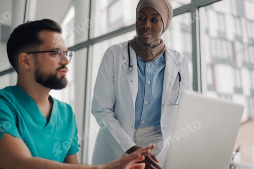Preview: Medical team discussing patient data on laptop in hospital