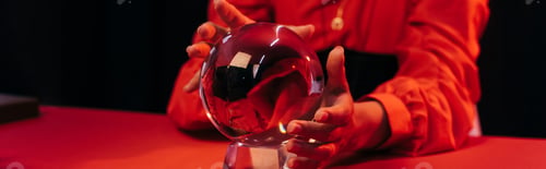 Preview: cropped view of blurred fortune teller predicting near crystal ball isolate on black, banner