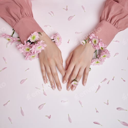 Preview: Hands Surrounded by Pink Flowers on Pastel Background