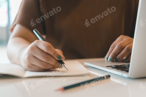 Preview: hand woman writing notes workspace using a computer. communication and information