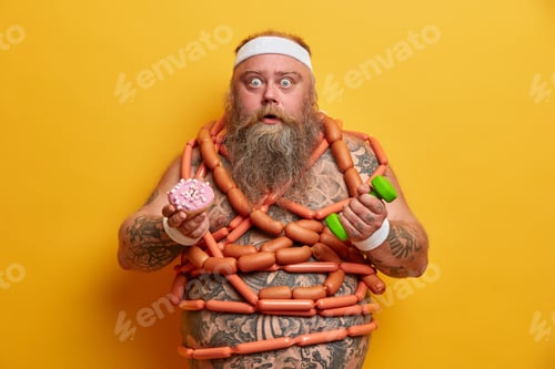 Preview: Stunned bearded overweight adult man has imbalanced nutrition has big tattoed belly wrapped with sau