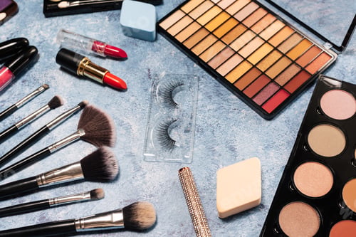 Preview: set of decorative cosmetics, makeup brushes false eyelashes on a blue background. the view from top