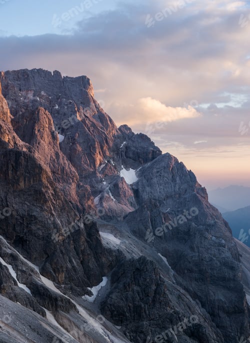 Preview: Vertical shot of a mountain with a cloudy sky in the background