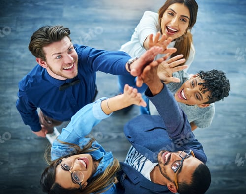 Preview: High angle shot of a group of
young businesspeople cheering in a modern office