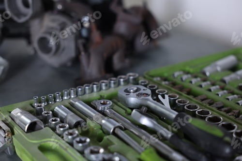 Preview: Different auto parts and tools on table indoors, closeup