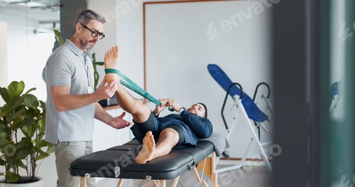Preview: Chiropractor, people and band for stretching legs at clinic, helping and recovery on table. Men, fl