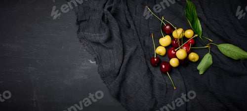 Preview: Ripe red and yellow cherries on a black background. summer berry