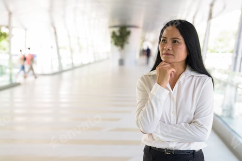 Preview: Mature beautiful Asian businesswoman relaxing at the footbridge