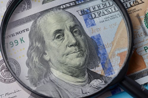 Preview: Fragment of one hundred dollar bill with a portrait of Benjamin Franklin under a magnifying glass