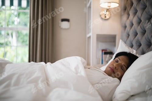 Preview: Mature woman sleeping on bed at home