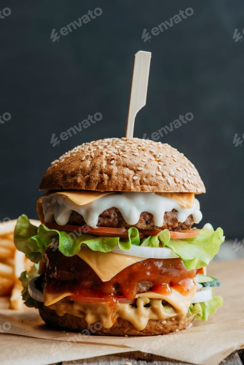 Preview: big traditional american homemade cheeseburger on baking paper