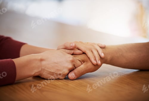 Preview: Cropped shot of an unidentifiable young woman holding her friends hand in support in a coffee shop