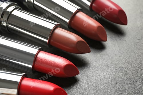 Preview: Set of different lipsticks on grey background, closeup