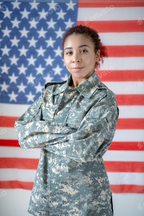 Preview: Serious young pretty servicewoman wearing camouflage uniform