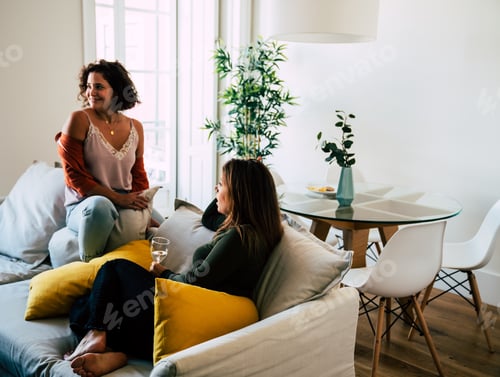 Preview: Two young women drinking wine in a modern stylish apartment